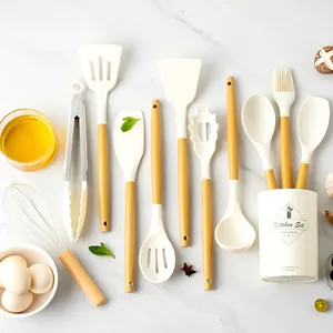 11-piece cream silicone kitchen utensil set with wood-grain handles on marble background