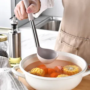 Louche à soupe en silicone résistant à la chaleur avec manche en inox dans une marmite.