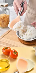Action shot of non-stick silicone rice paddle with stainless steel handle scooping rice.