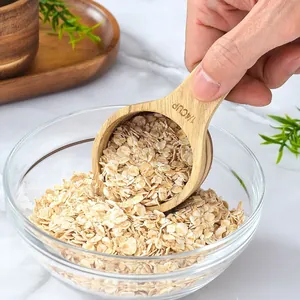 Acacia wood measuring spoon 1/4 cup filled with oatmeal in a bright kitchen scene