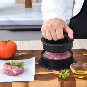 Manual black round burger press maker tool for making meat patties in a kitchen setting
