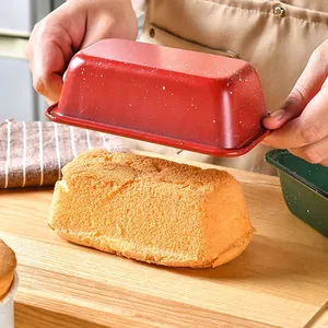 Non-stick red carbon steel loaf pan showing freshly baked cake on a wooden board