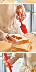 Close-up action shot of a red silicone spatula spreading sauce on fresh bread slices