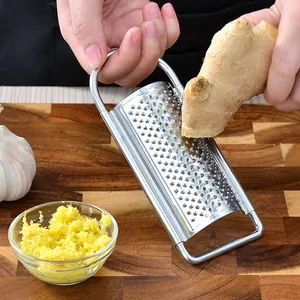 Stainless steel hand grater for ginger and garlic on a wooden board