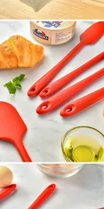 Close-up detail of high-quality red silicone spatulas with ergonomic hanging handles.
