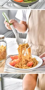 Close-up of a white and green silicone pasta fork server lifting spaghetti from a plate