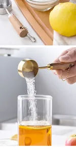 Detailed view of gold-plated stainless steel measuring spoon pouring sugar into tea