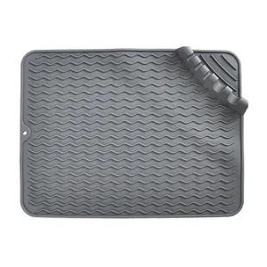 Grey silicone drying mat with wavy ridges and built-in utensil holder