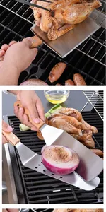 Detail of stainless steel Teppanyaki spatulas flipping chicken and onions on a grill.
