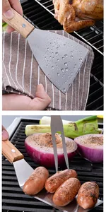 Close-up of stainless steel spatula and fork used for grilling sausages and onions