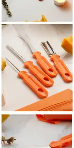 Close-up detail showing four different orange handles of Halloween pumpkin carving tools