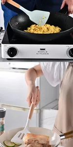 Close-up of heat-resistant silicone spatulas with wooden handles being used in cooking