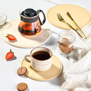 Minimalist round silicone heat insulation mats with coffee set and strawberries on a table.