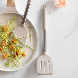 Ensemble de spatules modernes en silicone beige et acier inoxydable sur fond de marbre