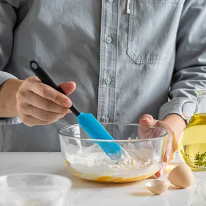 Versatile blue silicone spatula mixing flour in a glass bowl for professional baking