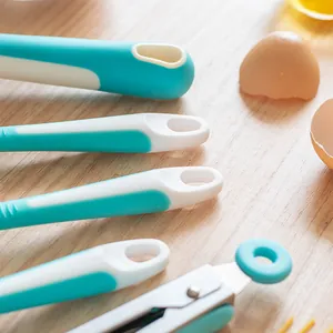Set van turquoise bakgereedschap met handvatten met ophanggat op een houten tafel