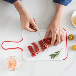 White anti-slip PP plastic cutting board with red handle for meat and fruit slicing