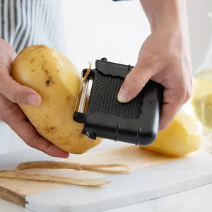 Multifunctional 3-in-1 vegetable peeler peeling a large potato on a board