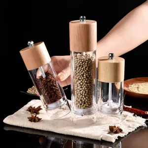 Set of transparent acrylic pepper grinders with natural wood lids for kitchen spices