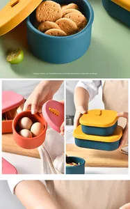 Close-up of colorful silicone food storage containers with embossed cartoon lids.