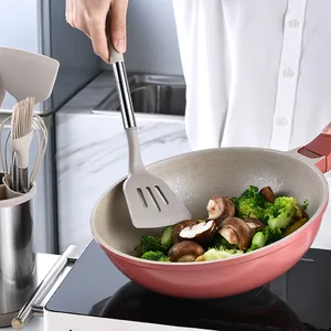 Grey silicone slotted spatula with stainless steel handle for stir-frying in kitchen