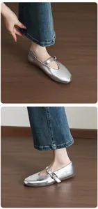 Detailed view of silver metallic Mary Jane flat shoes with buckle strap