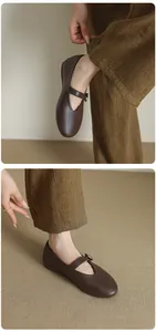 Detailed close-up of dark brown leather Mary Jane flats with vintage buckle strap