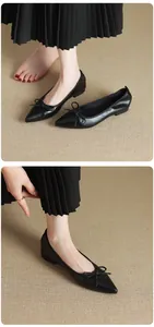 Dettaglio di ballerine nere a punta stile francese con decorazione a fiocco