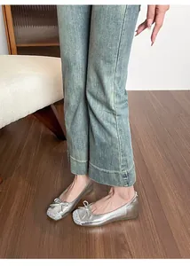 Eleganti ballerine metallizzate argento con fiocco e punta glitterata, indossate al piede.