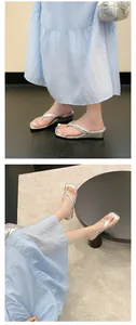 Nahaufnahme silberner Flip-Flop-Sandalen mit Keilabsatz und quadratischer Spitze