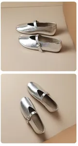Close-up of metallic silver Mary Jane flats with buckle strap and round toe