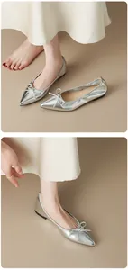 Vista dettagliata di eleganti ballerine metallizzate argento a punta con decorazione a fiocco