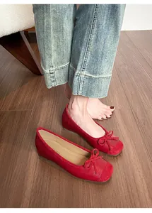 Close-up detail of elegant red French-style ballet flats featuring a delicate bow