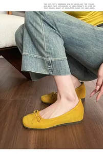 Yellow suede ballet flats with delicate bow and inner heightening detail on feet.