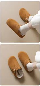 Close-up detail of brown suede platform clogs featuring warm fleece lining and buckle straps