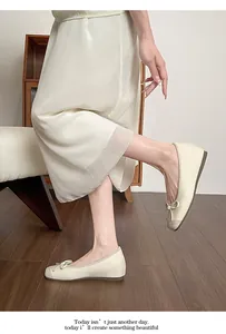 Side view showing elegant creamy white ballet flats with bow detail and textured toe.