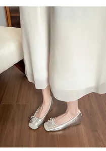 Elegant silver French style ballet flats with bow detail and hidden wedge heel on model