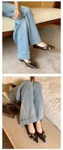 Macro detail of French style pointed-toe brown flats with decorative metal buckle on model
