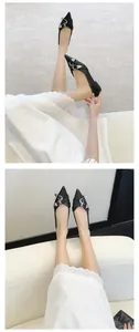Detailed view of elegant black pointed-toe flats with stylish double buckle straps.