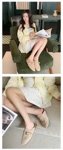 Close-up of beige suede mules with a classic buckle detail worn with casual outfit