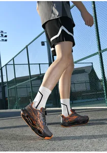 Close-up detail of grey running shoes with orange patterns on an outdoor court