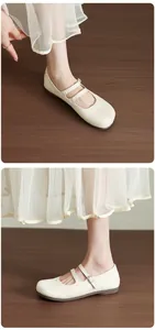 Élégantes chaussures Mary Jane plates beiges à bout fendu avec bride à boucle réglable.