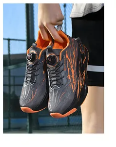 Close-up detail of outdoor running shoes featuring rotary lacing and vibrant orange splash design