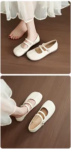 Détail de ballerines Mary Jane crème avec couture Tabi sur fond de bois rustique