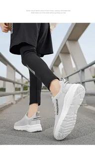 Close-up of grey marathon running shoes worn by a model walking on an outdoor bridge.