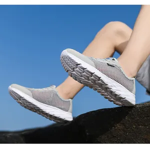 Détail de chaussures de course en mesh respirant gris pour homme avec semelle blanche