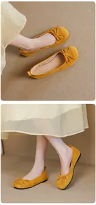 Macro view of yellow suede ballet flats featuring a delicate bow and soft flat sole