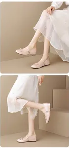 Detalle de elegantes zapatos Mary Jane de satén champán con lazo sobre una modelo
