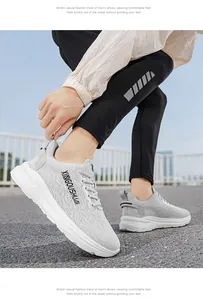 Close-up view of grey men's lightweight running shoes worn by a model in an outdoor setting