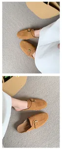 Detailed view of women's tan suede mules with buckle strap and casual thick sole design